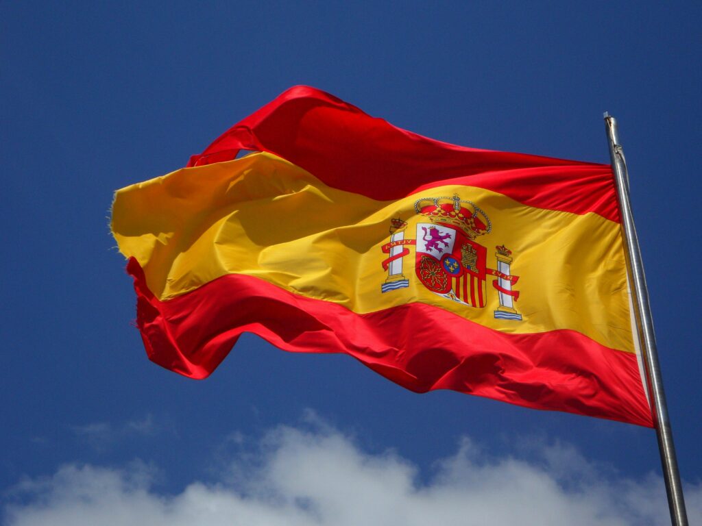 Bandera de España ondeando, representando la cultura y el idioma español, ideal para estudiantes de nivel avanzado o DELE C1/C2.
