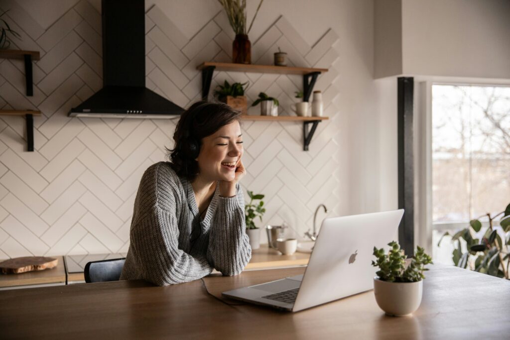 Woman smiling and speaking confidently into laptop during language practice.