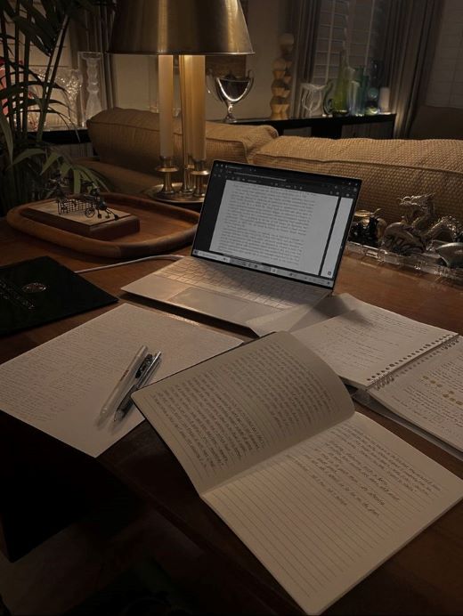 Translator working on a project with a laptop and documents on the table.