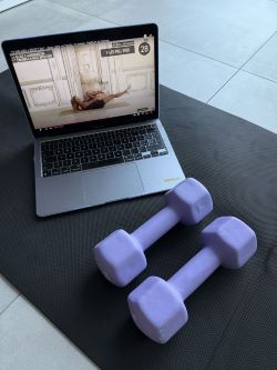 Home workout setup with laptop showing fitness video – ideal for fitness translation content