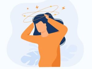 Flat illustration of a person with blue hair holding their head in stress, with yellow rings, stars, and lightning bolts circling above, representing a "brain freeze," cognitive overload, and inability to speak clearly.