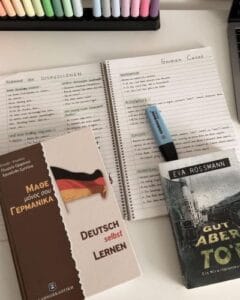 German grammar notebooks and study books on a desk, showing handwritten notes on German cases.